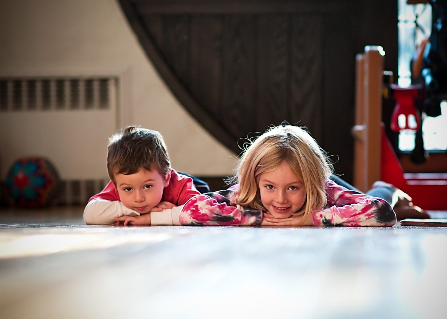 Two children laying on the floor in pajamas