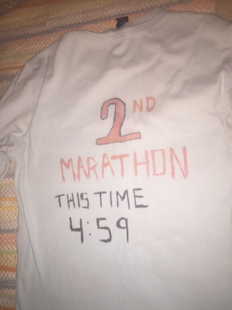 A close up of the back of a shirt with the words " 2 nd marathon this time 4 : 5 9 ".